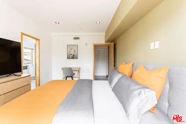 a bedroom with a bed and a flat screen tv