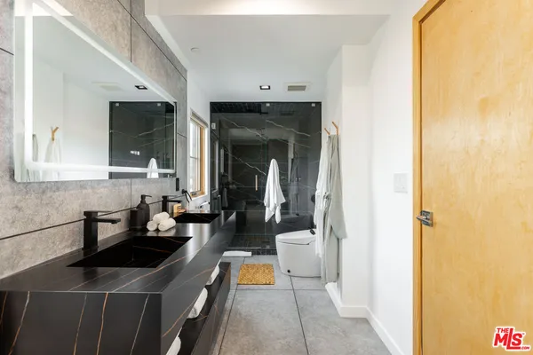 a kitchen with a sink and a refrigerator a mirror