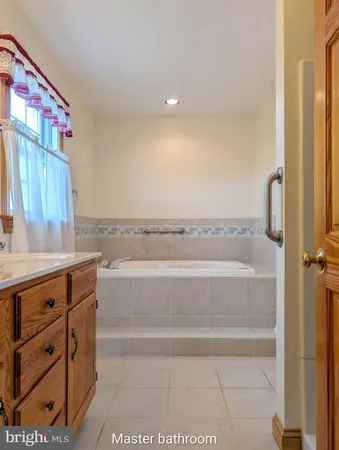 an empty room with wooden floor and fan