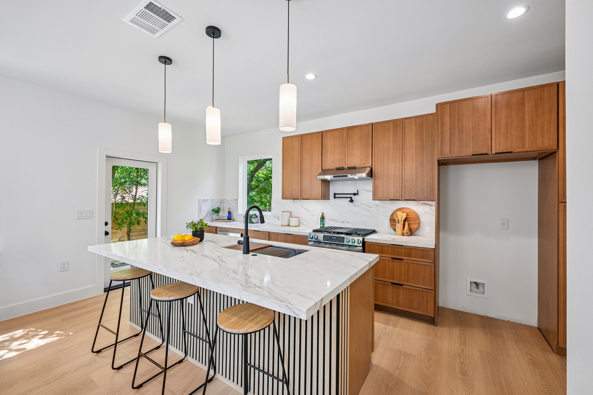 513 West Odell Street, Unit B Austin, TX 78752 - Photo 10 of 38 A well-lit kitchen with sleek wooden cabinetry and a quartz island perfect for entertaining.