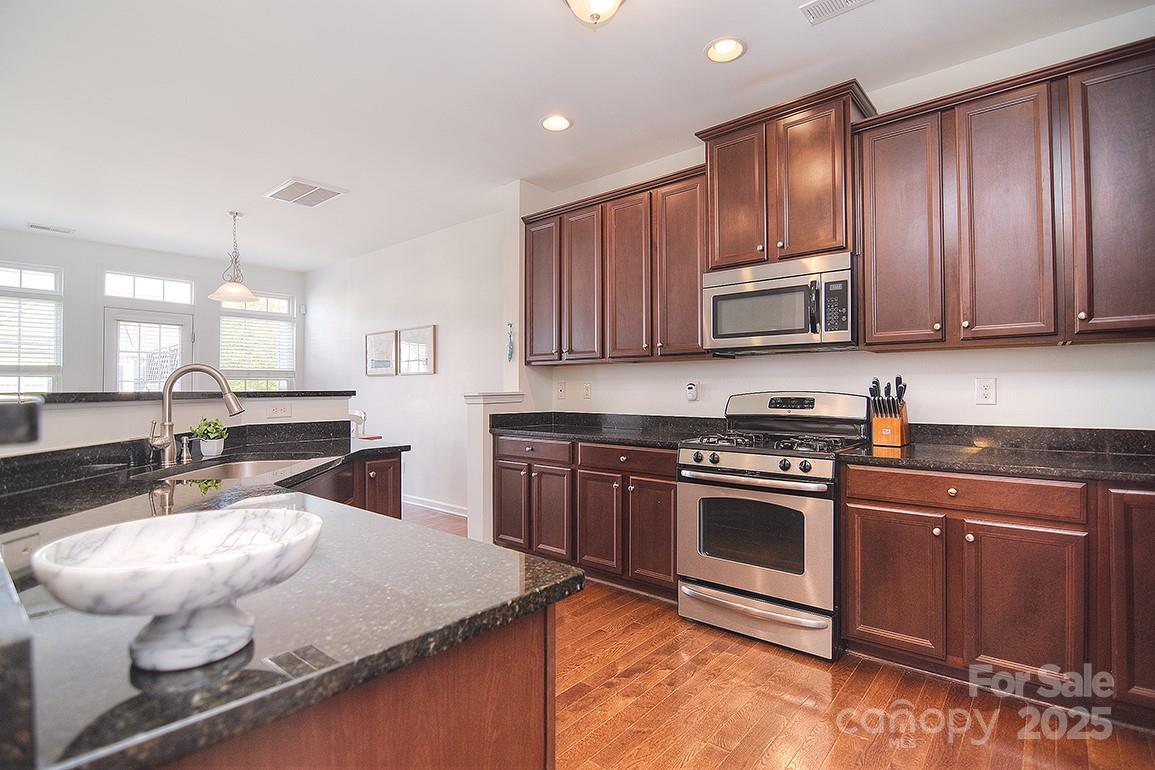 6134 Rockefeller Lane Charlotte, NC 28210 - Photo 11 of 47 a kitchen with stainless steel appliances granite countertop a stove a sink and a microwave