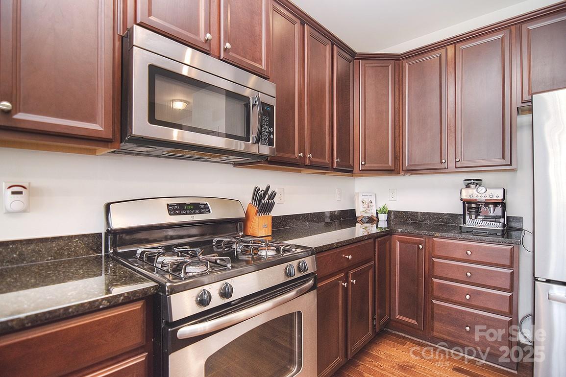 6134 Rockefeller Lane Charlotte, NC 28210 - Photo 13 of 47 a kitchen with granite countertop a stove and a microwave