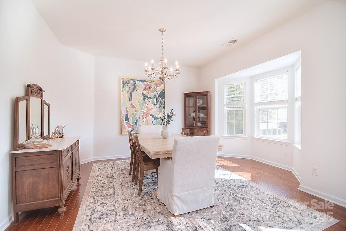 6134 Rockefeller Lane Charlotte, NC 28210 - Photo 17 of 47 a view of a dining room with furniture a chandelier and wooden floor