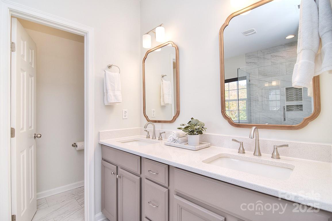 6134 Rockefeller Lane Charlotte, NC 28210 - Photo 34 of 47 a bathroom with double vanity sinks and a mirror