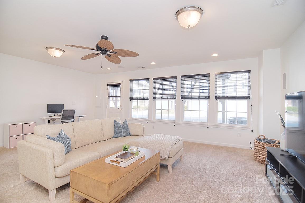6134 Rockefeller Lane Charlotte, NC 28210 - Photo 7 of 47 a living room with furniture a ceiling fan and a window