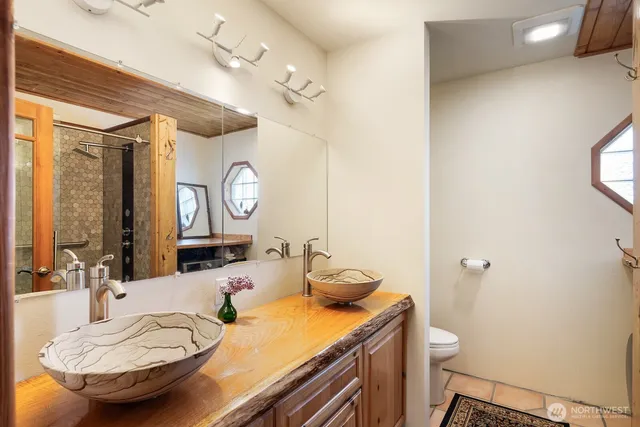 a bathroom with a granite countertop sink mirror vanity and toilet