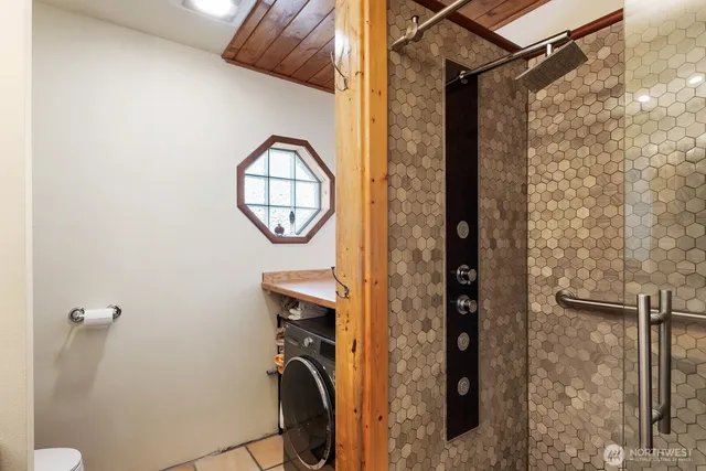 a view of a hallway with wooden floor and a bathroom