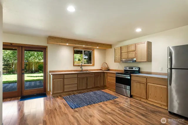 a kitchen with a refrigerator a stove top oven and a sink