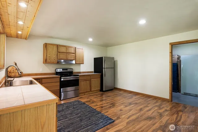 a kitchen with stainless steel appliances granite countertop a sink stove and refrigerator