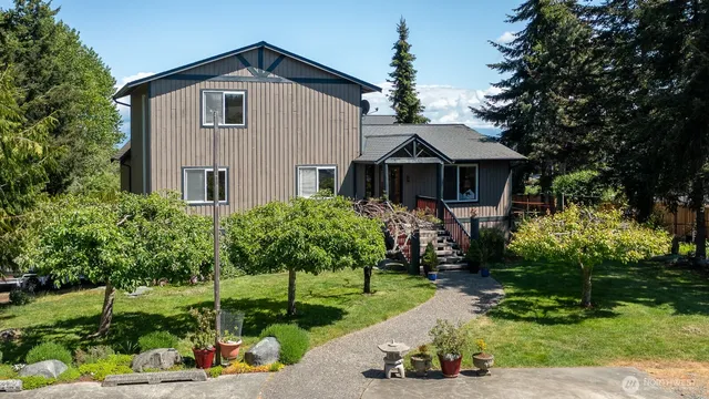 a front view of a house with a yard and potted plants