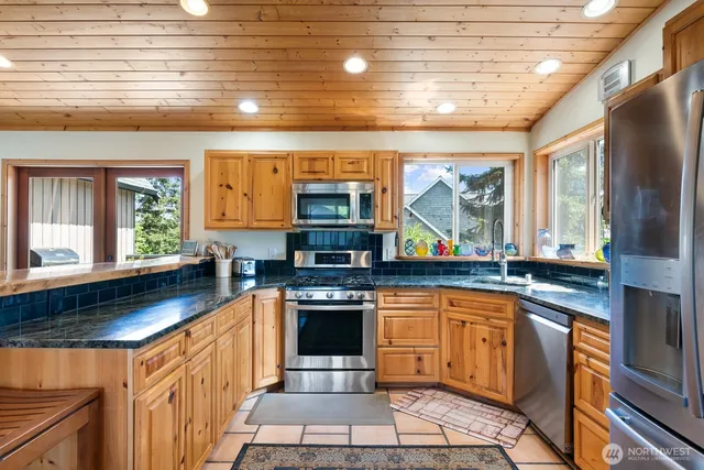 a kitchen with stainless steel appliances granite countertop a sink and cabinets