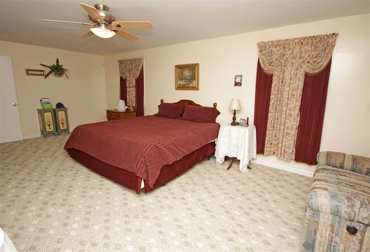 384 Bybee Road Louisa, VA 23093 - Photo 19 of 23 a bedroom with a bed and a chandelier