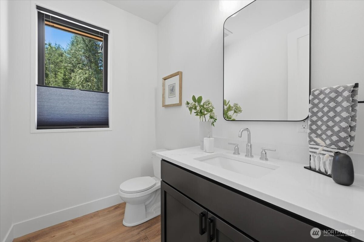 7416 Lake Alice Road Southeast Fall City, WA 98024 - Photo 14 of 40 a bathroom with a granite countertop sink a toilet and a mirror