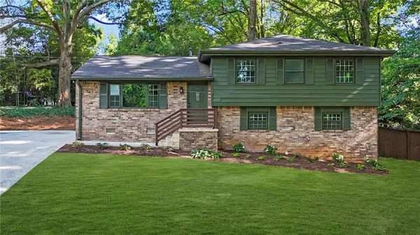 a view of a house with a yard and sitting area