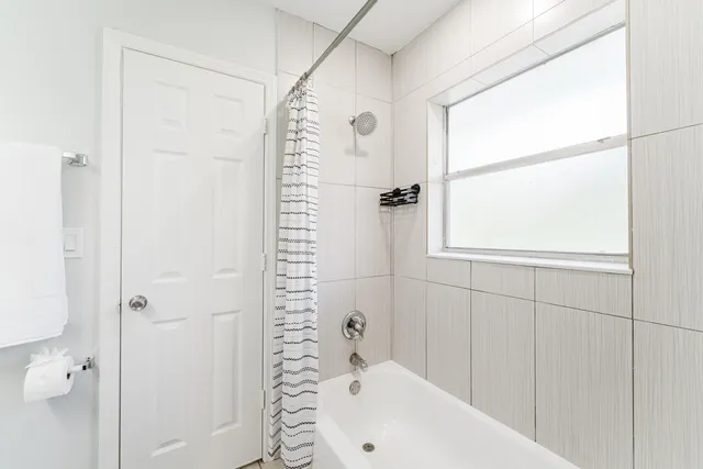 a bathroom with a white bath tub and a shower