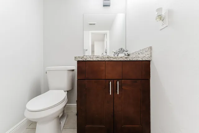 a bathroom with a toilet a sink and mirror