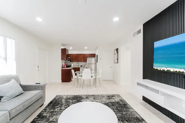 a living room with furniture a flat screen tv and a rug