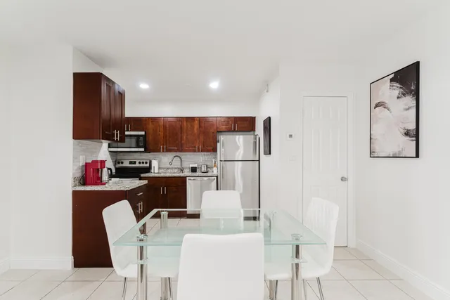 a kitchen with stainless steel appliances kitchen island granite countertop a refrigerator and a stove top oven