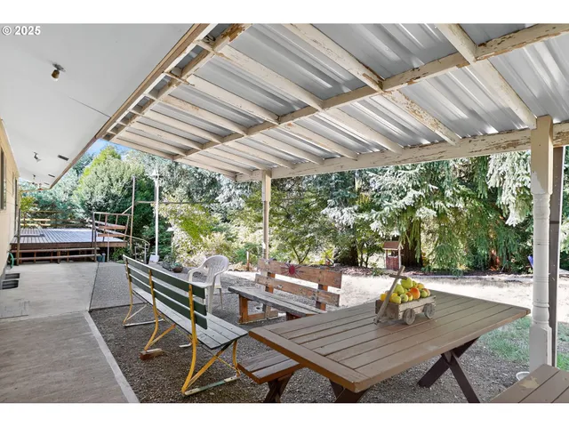 a view of a patio with table and chairs and couches with wooden floor