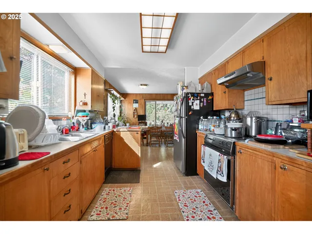 a kitchen with stainless steel appliances kitchen island granite countertop a sink dishwasher stove and refrigerator