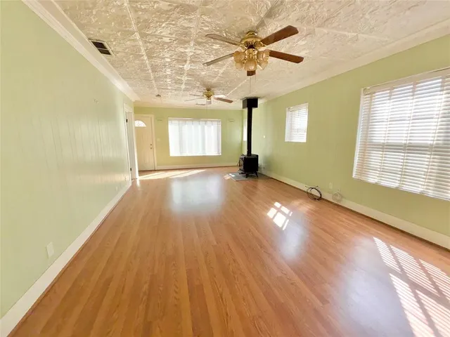 a view of a room with wooden floor and a ceiling fan