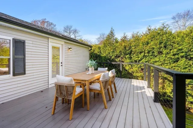 a view of a patio with table and chairs with wooden floor and fence