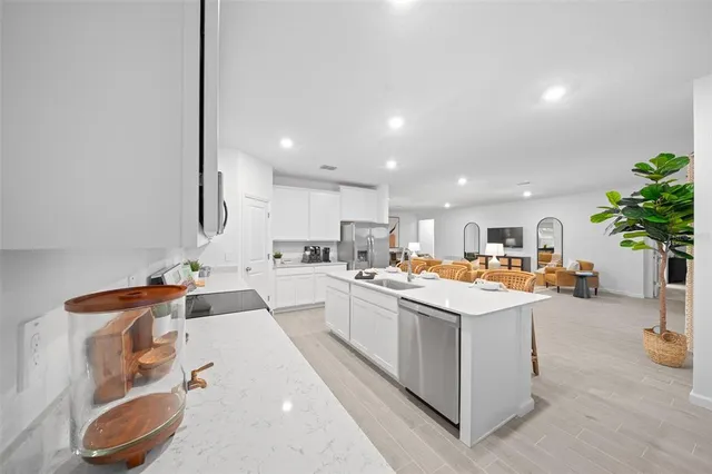 a kitchen with stainless steel appliances granite countertop a sink a stove and a refrigerator