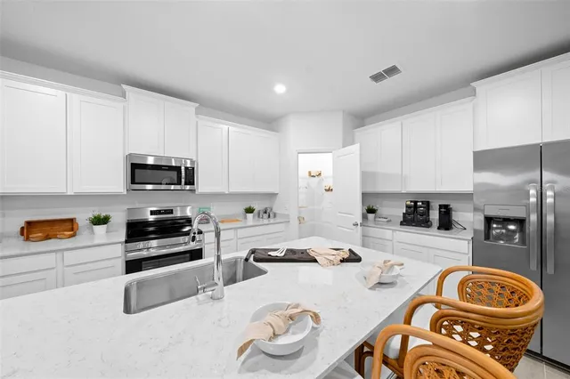 a living room with furniture kitchen view and a wooden floor