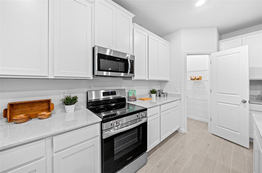 8735 Southwest 67th Circle Ocala, FL 34476 - Photo 2 of 35 a kitchen with stainless steel appliances white cabinets and a stove a refrigerator