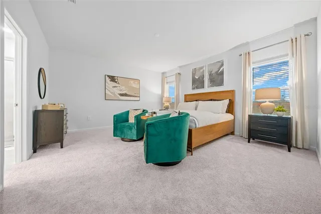 a spacious bedroom with a bed and a large mirror next to a window