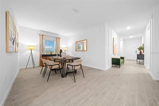 a kitchen with a dining table chairs and a refrigerator