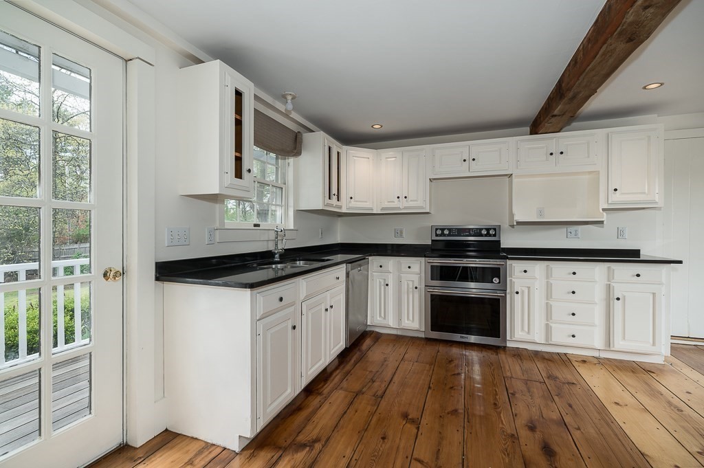 60 Walnut Road Wenham, MA 01984 - Photo 4 of 42 a kitchen with granite countertop a stove top oven a sink dishwasher and white cabinets with wooden floor
