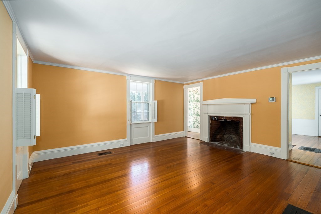 60 Walnut Road Wenham, MA 01984 - Photo 7 of 42 an empty room with wooden floor fireplace and windows