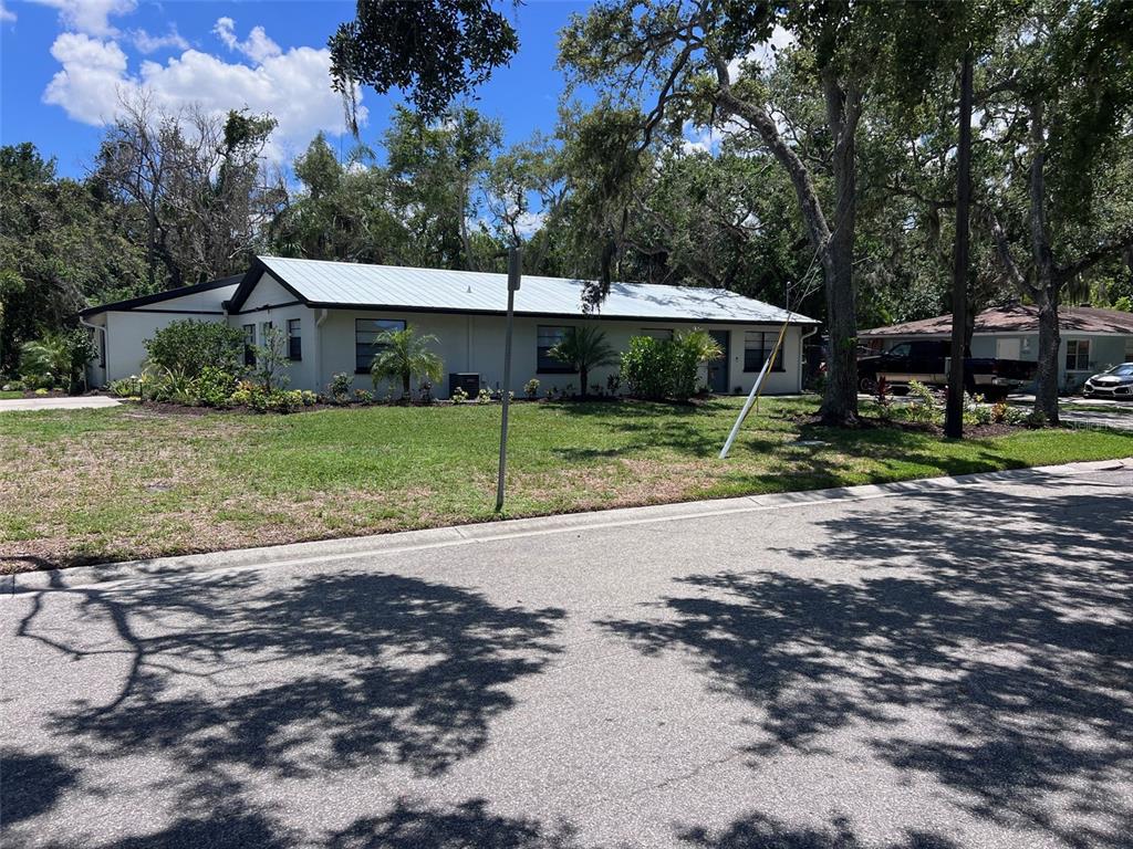a view of a house with backyard and trees