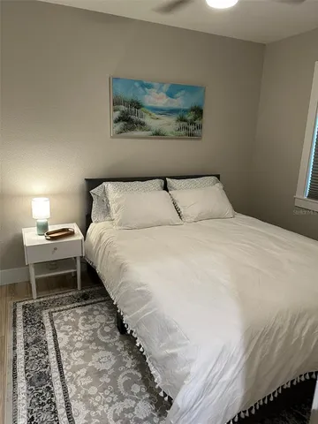 a bedroom with a bed and a painting on the wall