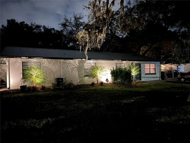 a front view of a house with a yard and trees