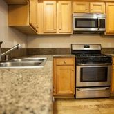 a kitchen with stainless steel appliances granite countertop a stove microwave and sink