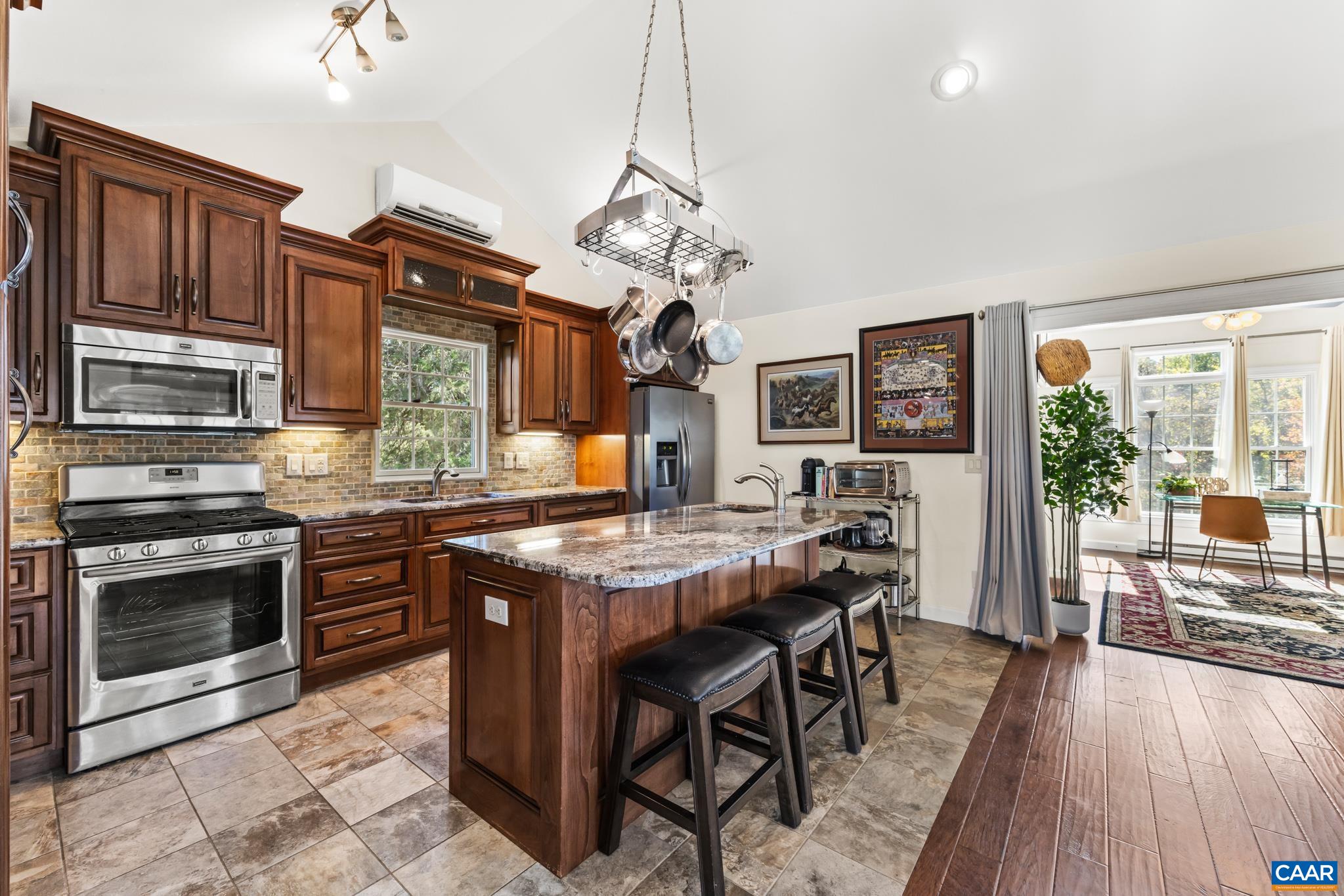 234 Creek Road Afton, VA 22920 - Photo 18 of 68 a kitchen with stainless steel appliances granite countertop a stove top oven a sink dishwasher a dining table and chairs with wooden floor