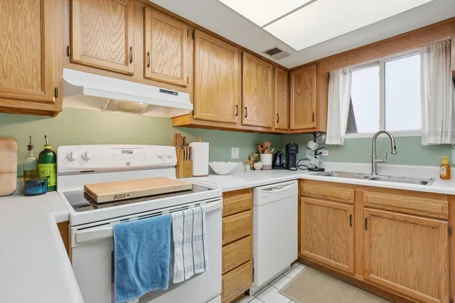 a kitchen with cabinets appliances a sink and a window