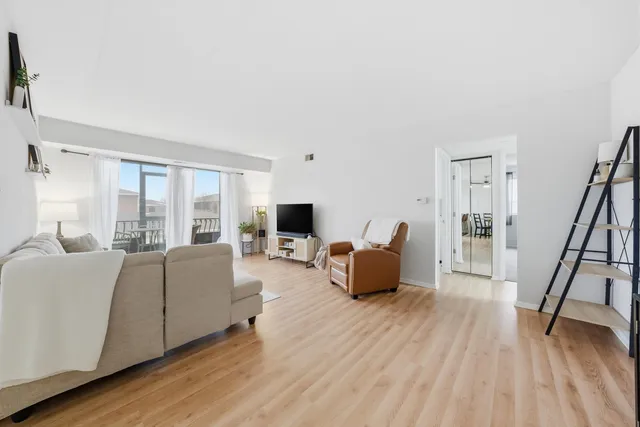a living room with furniture flat screen tv and a large window