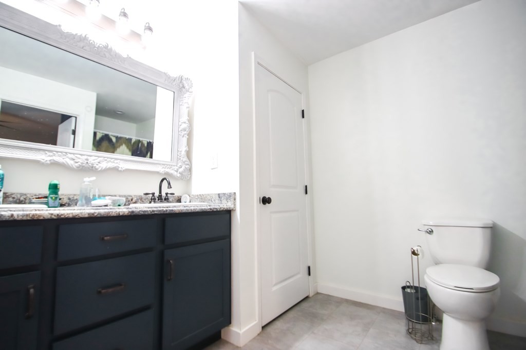 131 Collingwood Road Walling, TN 38587 - Photo 10 of 26 a bathroom with a granite countertop toilet sink and mirror