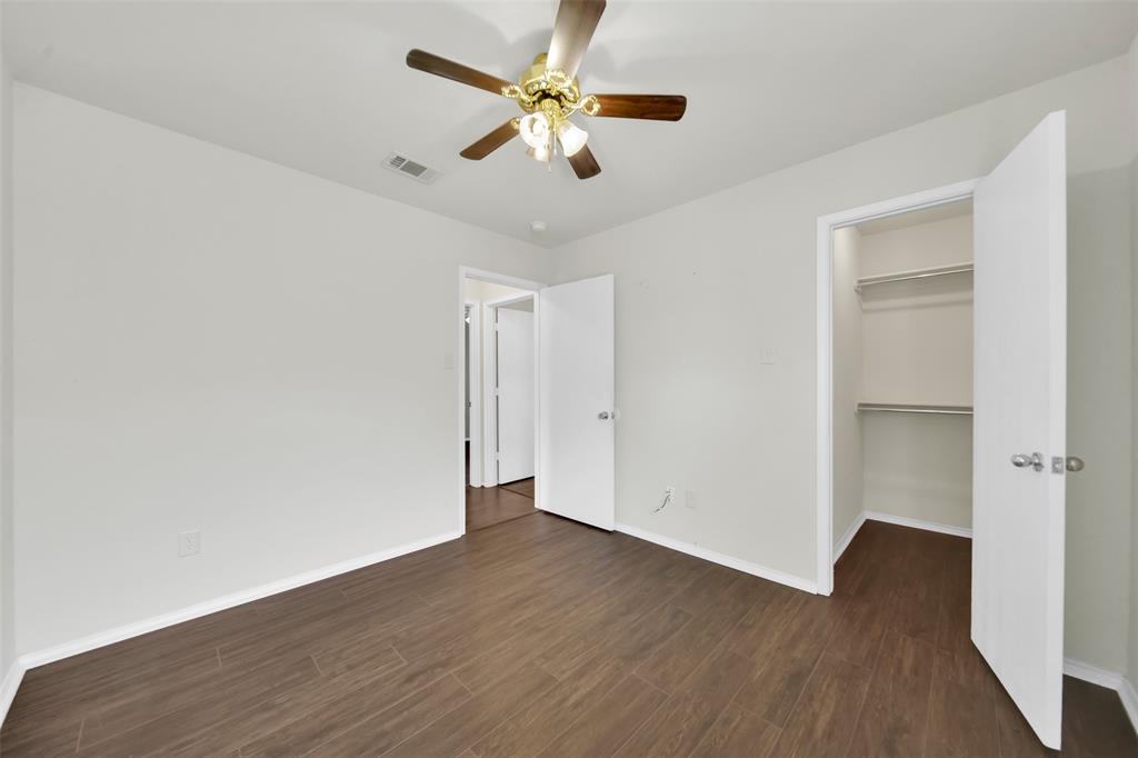 4221 Fiste Denton, TX 76207 - Photo 22 of 26 Unfurnished bedroom with dark wood-type flooring, ceiling fan, a walk in closet, and a closet