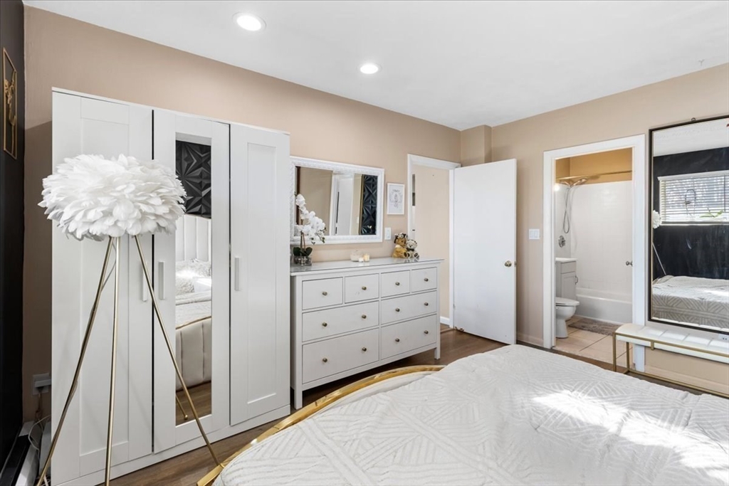 115 Grove Street, Unit 11 Boston, MA 02132 - Photo 14 of 29 a bedroom with a bed and a flat tv screen