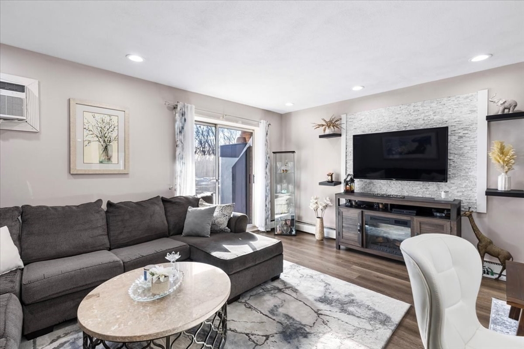 115 Grove Street, Unit 11 Boston, MA 02132 - Photo 6 of 29 a living room with furniture and a flat screen tv