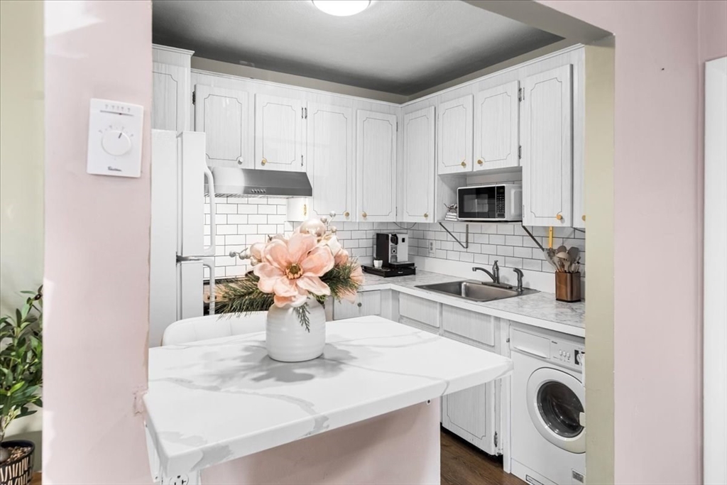 115 Grove Street, Unit 11 Boston, MA 02132 - Photo 9 of 29 a kitchen with a sink a stove and cabinets