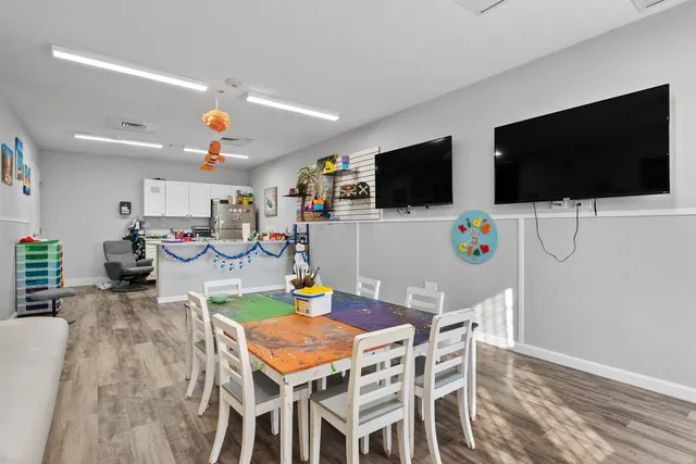 a view of multiple houses with yard and sitting area