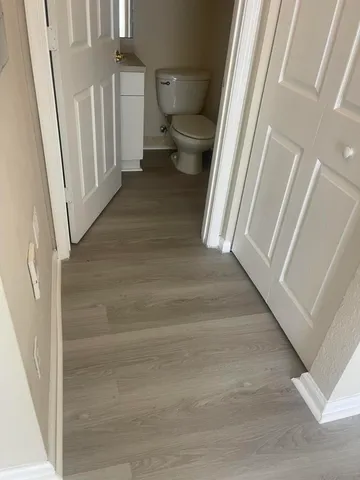a view of a hallway with wooden floor and staircase