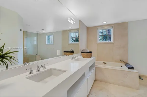 a bathroom with a tub a sink and mirror