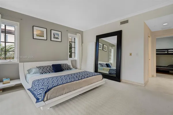 a bedroom with a bed and a large mirror