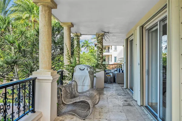 a view of a balcony with chairs and a potted plant